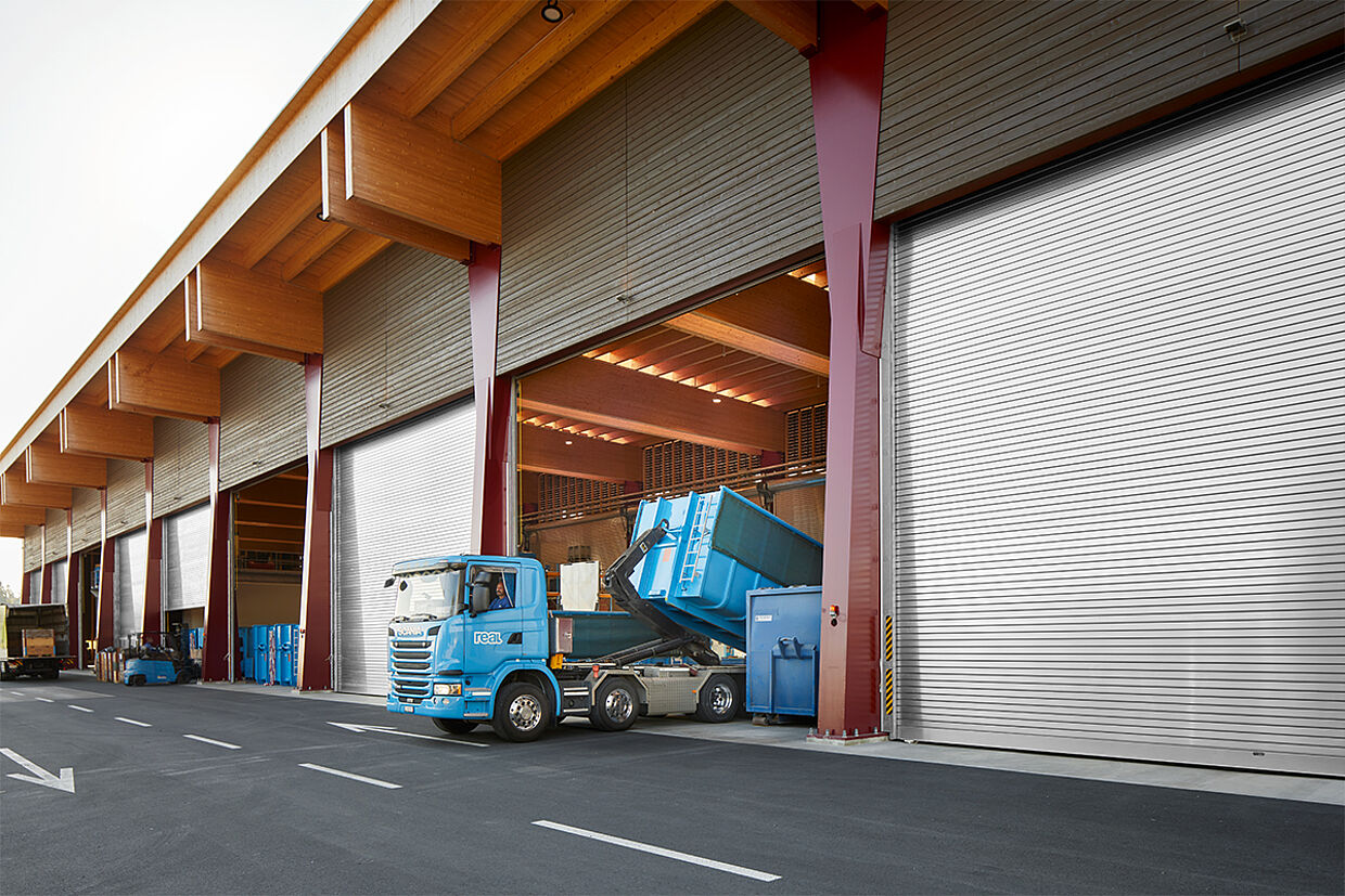 Ein Lastwagen fährt durch das geöffnete Industrierolltor beim REAL Recyclingcenter Emmenbrücke