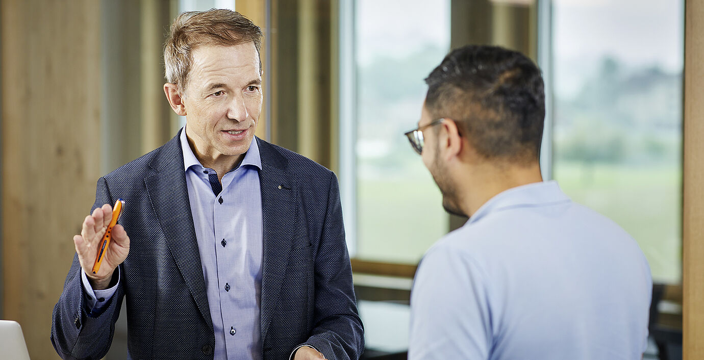 Martin Zumstein der Vorsitzende der REAL Geschäftsleitung im Gespräch mit einem Mitarbeiter